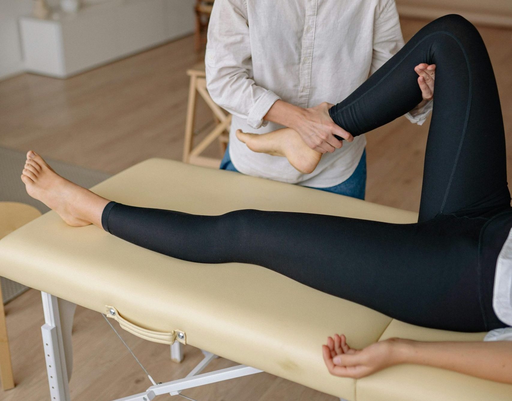 Woman receiving a leg massage in a serene spa environment, promoting relaxation and wellness.
